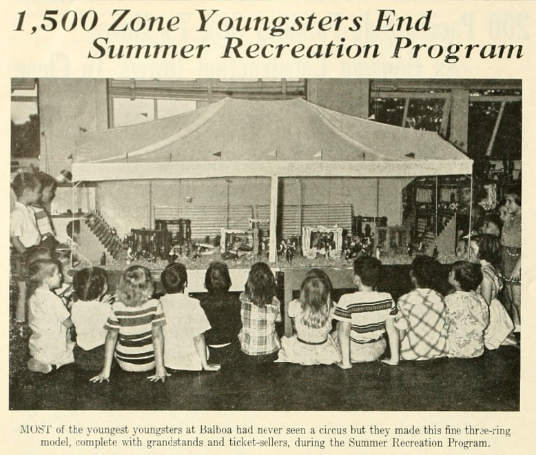 Photo of children looking at model of a three ring circus that they had build during a summer recreation program.