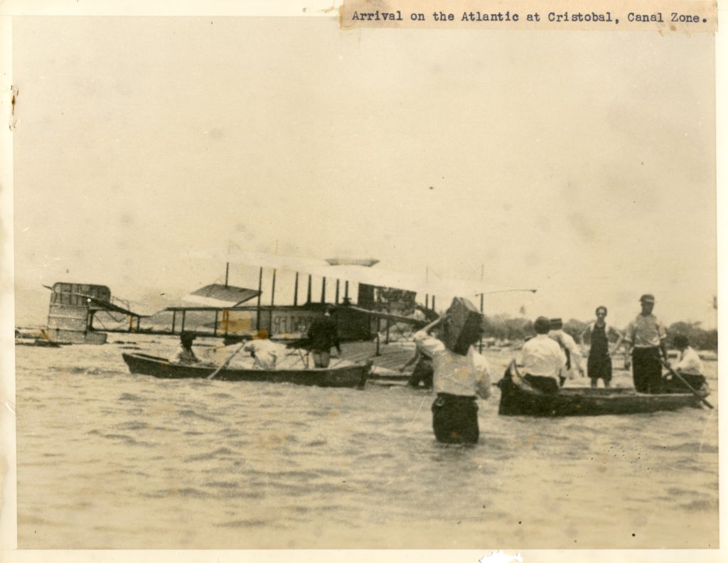 Boats, an airplane, and men in the water of the Atlantic Ocean near Cristobal, Canal Zone.
