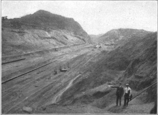 Two men stand at the side of the Culebra Cut during construction of the Panama Canal.