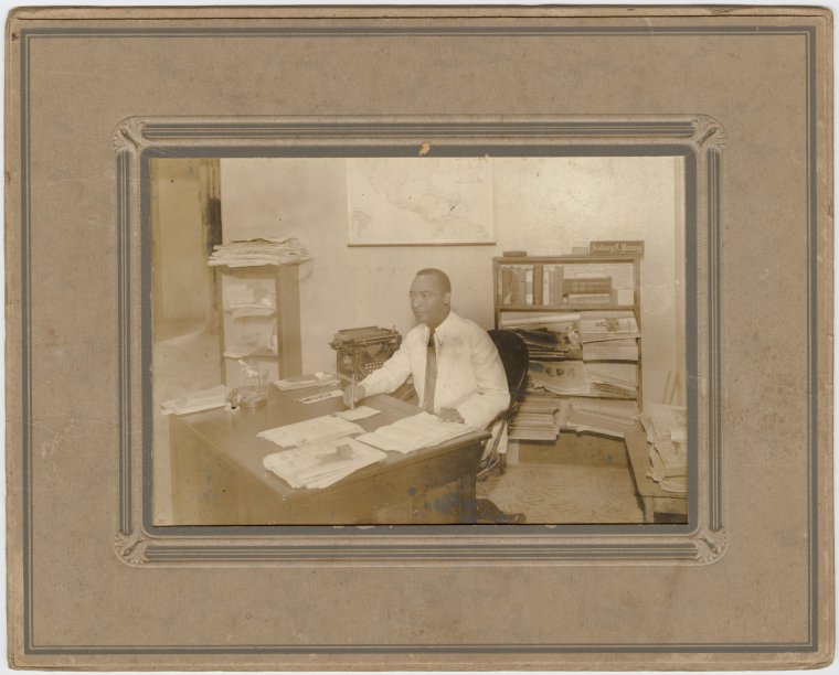 Sidney Young working at his desk at the Panama Tribune